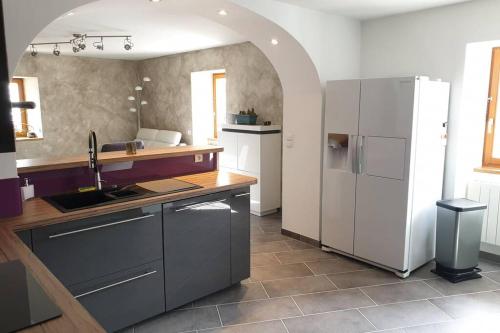 a kitchen with a white refrigerator and a counter at Villard au cœur de la vallée verte entre lac et montagne in Villard-sur-Boëge