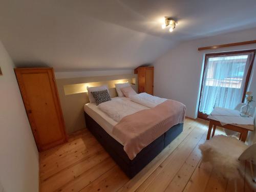 1 dormitorio con 1 cama en una habitación con ventana en Zum Schneider, en Finkenberg
