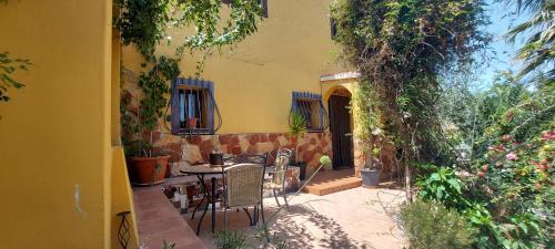 un patio con mesa, sillas y plantas en Casa Joya, en La Losilla