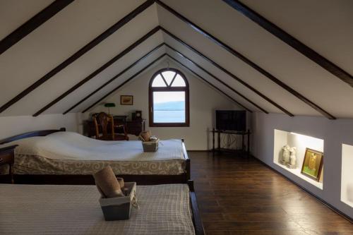 a attic bedroom with a large bed and a window at Carobni breg in Golubac