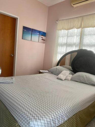 a bedroom with a bed with a black head board at Beverley's Guest House, Nevis in Nevis