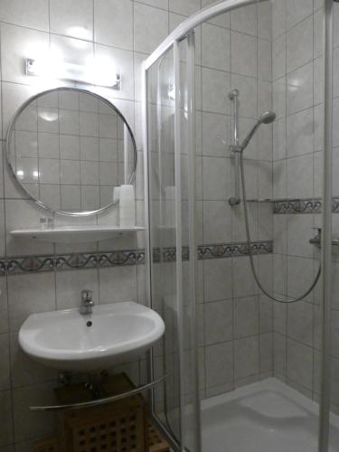 a bathroom with a sink and a shower with a mirror at Haus Daheim in St. Wolfgang