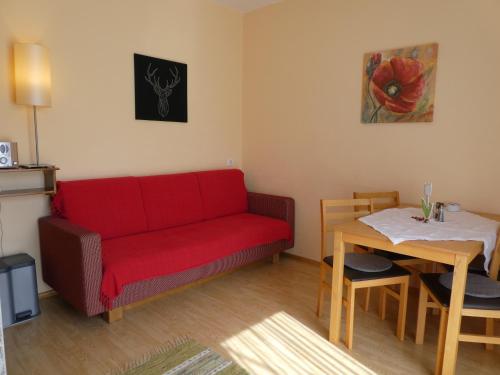 a living room with a red couch and a table at Haus Daheim in St. Wolfgang