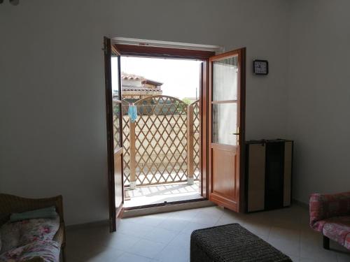 uma sala de estar com uma porta aberta para uma varanda em Appartamento al centro di Budoni em Budoni