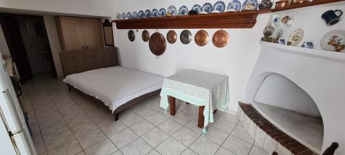 スキロスにあるMini Traditional Houseのテーブルと皿が壁に掛けられた部屋