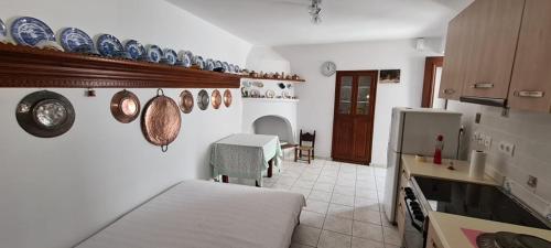 Habitación con cama y cocina con platos en la pared. en Mini Traditional House en Skyros