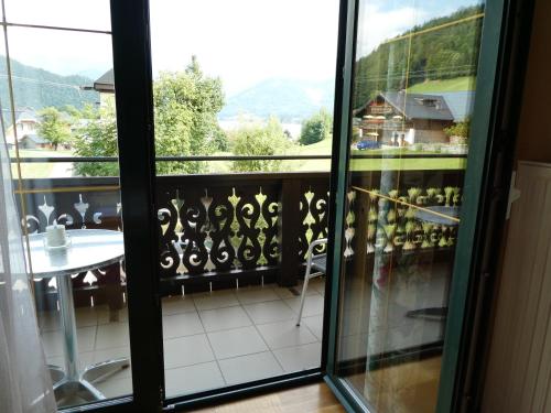 a balcony with a table and a glass door at Haus Daheim in St. Wolfgang