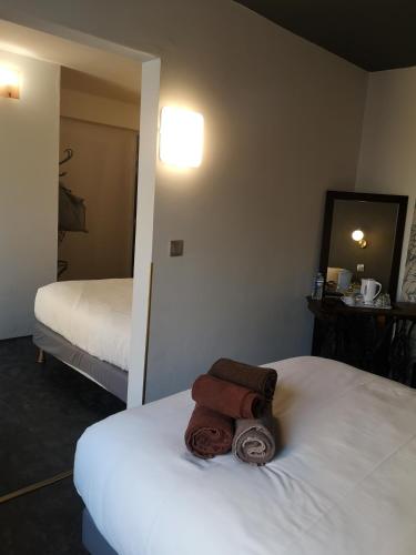 a hotel room with two beds with towels on the bed at The Originals Boutique, Hôtel d'Angleterre, Le Havre, centre, plage in Le Havre