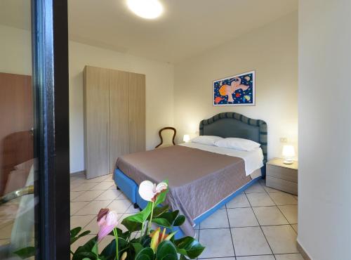 a bedroom with a bed and a plant in the foreground at B&B Nonna Teresa in Gragnano
