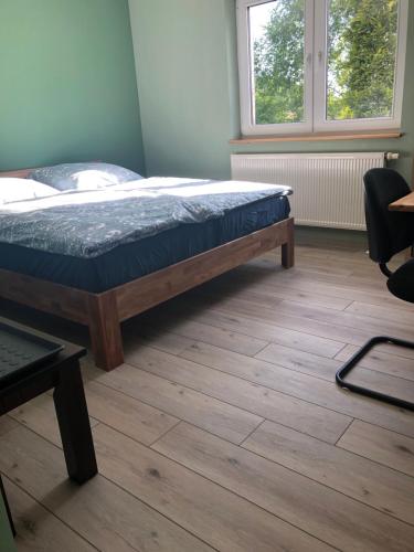 a bed in a room with a wooden floor at Fewo Kuller in Lauscha - Ernsthal am Rennsteig