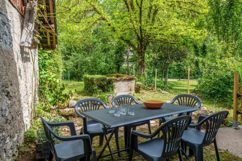 a table and chairs sitting on a patio at Cosy flat in an old farmhouse with garden in Seynod - Welkeys in Annecy