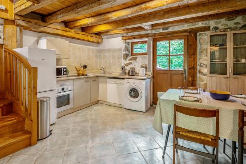 une cuisine avec un réfrigérateur blanc et une table dans l'établissement Appartement de la Vieille Ferme - Welkeys, à Annecy
