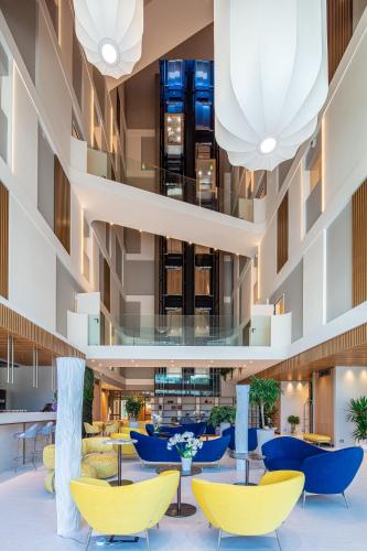a view of the lobby of a hotel with yellow chairs and tables at THE ONE CAORLE - Hotel & Apartments in Caorle