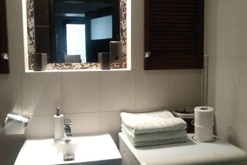 a bathroom with a sink and a mirror and towels at Apartament rodzinny 2 pokojowy. Widok na Snieżke. in Karpacz