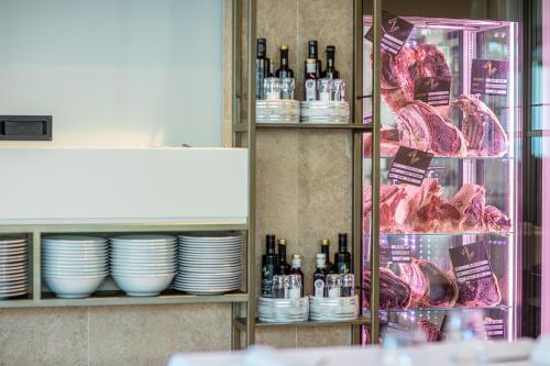 a shelf with dishes and bottles of wine and meat at THE ONE CAORLE - Hotel & Apartments in Caorle
