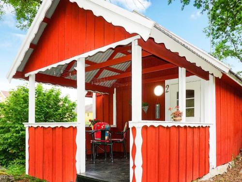 cobertizo rojo y blanco con mesa y sillas en 2 person holiday home in M NSTER S, en Mönsterås