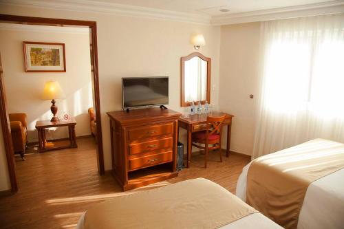 a hotel room with a bed and a television and a desk at Hotel Polanco in Mexico City