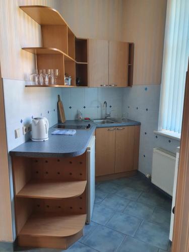 a kitchen with wooden cabinets and a counter top at Avanta in Liepāja