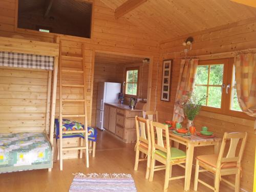 cocina y comedor de una cabaña de madera en Männiste Holiday Home, en Hiievälja
