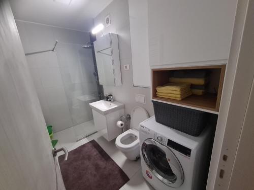 a small bathroom with a toilet and a washing machine at Metropolitan in Zenica