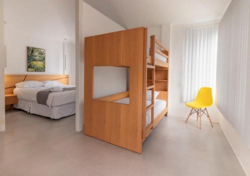 ein Schlafzimmer mit einem Etagenbett und einem gelben Stuhl in der Unterkunft Oceanic Lodge in Tonsupa
