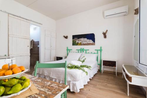 ein Schlafzimmer mit einem Bett und einer Obstschale auf einem Tisch in der Unterkunft Casetta Marilena in Ostuni