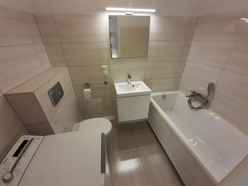 La salle de bains est pourvue de toilettes, d'une baignoire et d'un lavabo. dans l'établissement MINILOFT Studio Centrum, à Suwałki