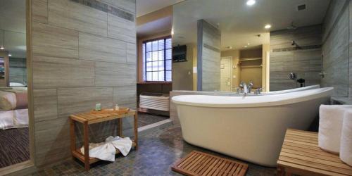a large bathroom with a tub and a sink at Postmarc Hotel and Spa Suites in South Lake Tahoe