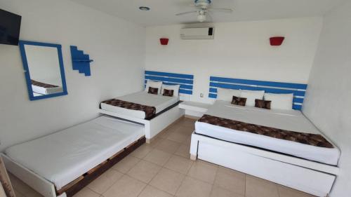 um quarto com duas camas e um espelho em Hotel Perlas del Golfo em Chachalacas