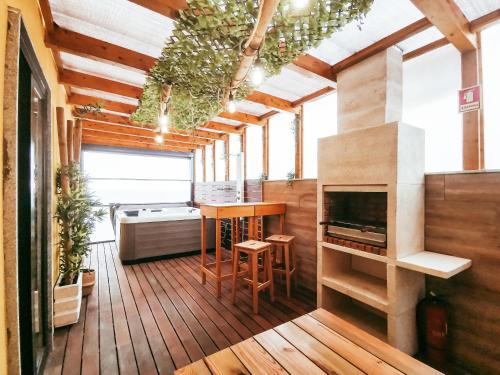 um quarto com lareira e uma cozinha com pisos em madeira em GOLD SUITE T2-PRAIA DO FURADOURO em Ovar