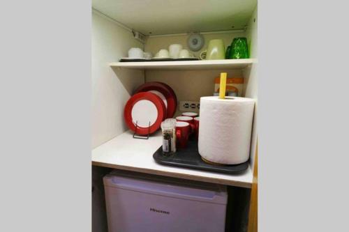 a shelf with a roll of paper towels and other items at CASA VERDE di Giorgio 10 mins walk from Piraeus port in Piraeus