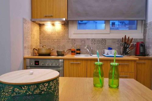 two green bottles sitting on a wooden table in a kitchen at CASA VERDE di Giorgio 10 mins walk from Piraeus port in Piraeus