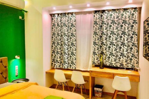 a bedroom with a window with two chairs and a table at CASA VERDE di Giorgio 10 mins walk from Piraeus port in Piraeus