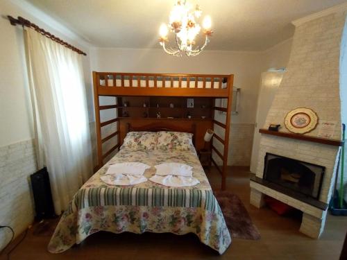 a bedroom with a bed with two pillows and a fireplace at Chalé dos Alpes I em Monte Verde in Monte Verde