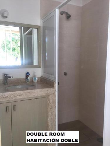 a bathroom with a shower and a sink and a mirror at Sea by C Apartments in Cancún