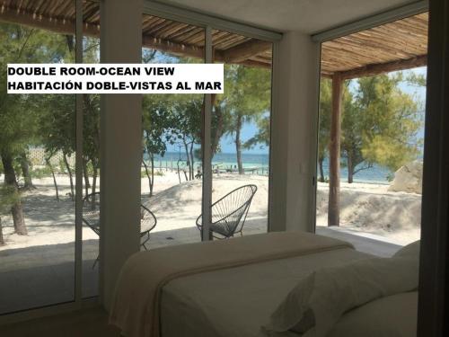 une chambre avec un lit et une vue sur la plage dans l'établissement Sea by C Apartments, à Cancún