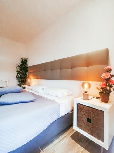 a bedroom with a large bed and a table with flowers at GOLD SUITE T2-PRAIA DO FURADOURO in Ovar