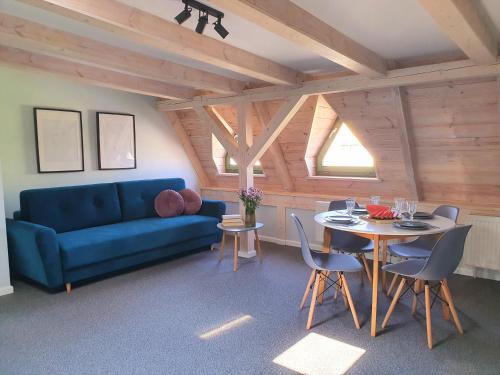 a living room with a blue couch and a table at Apartamenty K17 in Malbork