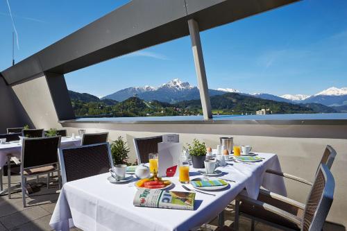 una mesa en un balcón con vistas a las montañas en Tivoli Hotel Innsbruck en Innsbruck