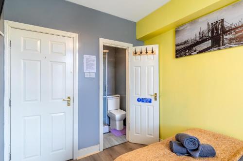 a room with a bathroom with a toilet and a door at CITY CENTRE en-suite rooms in Sunderland