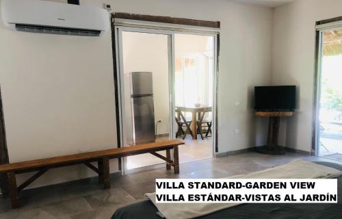 a living room with a bench and a tv at Sea by C Apartments in Cancún