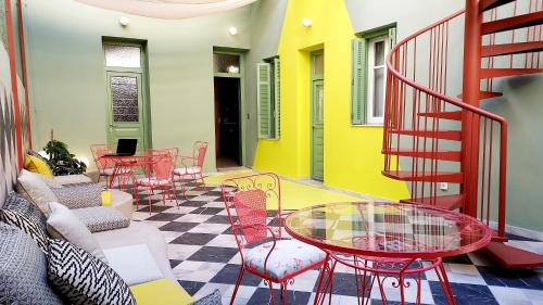 un patio avec des tables et des chaises et un escalier dans l'établissement KERAMOS Athens, à Athènes