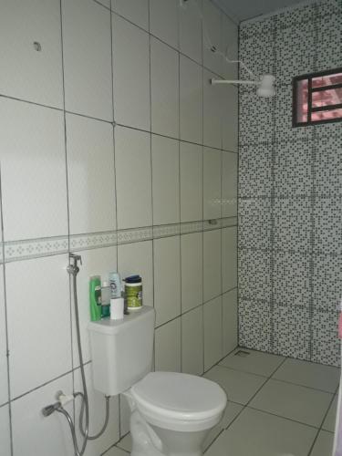 y baño blanco con aseo y ducha. en Casa da Vila de São Jorge en Alto Paraíso de Goiás