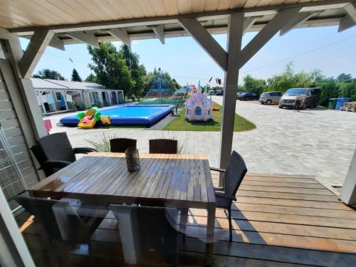 een patio met een tafel en stoelen en een speeltuin bij Holiday Homes 777 in Karwia