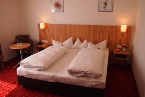 a bedroom with a bed with white pillows at Hotel am Bad in Tübingen