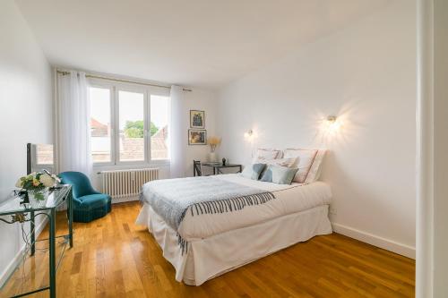 - une chambre blanche avec un lit et une fenêtre dans l'établissement Appartement Climatisé 7mn Centre Ville 95M2 4 Adultes Bébé Garage Sous sol Arrivée Autonome, à Dijon