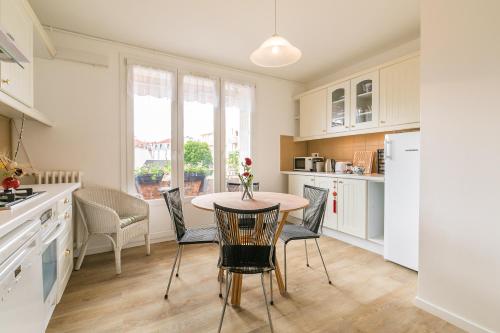 une cuisine avec une table et des chaises dans une cuisine dans l'établissement Appartement Climatisé 7mn Centre Ville 95M2 4 Adultes Bébé Garage Sous sol Arrivée Autonome, à Dijon