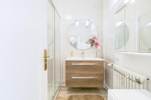a bathroom with a sink and a mirror at Appartement Climatisé 7mn Centre Ville 95M2 4 Adultes Bébé Garage Sous sol Arrivée Autonome in Dijon
