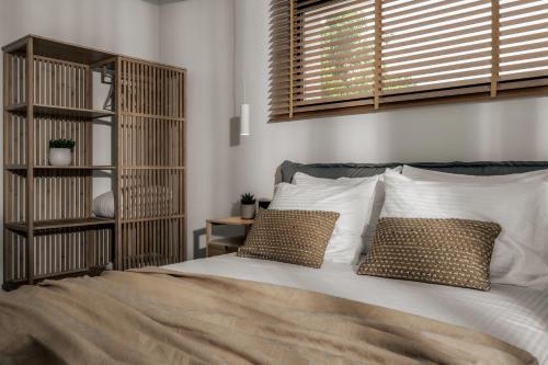 a bedroom with a bed with two pillows at Alas Suites in Alykes
