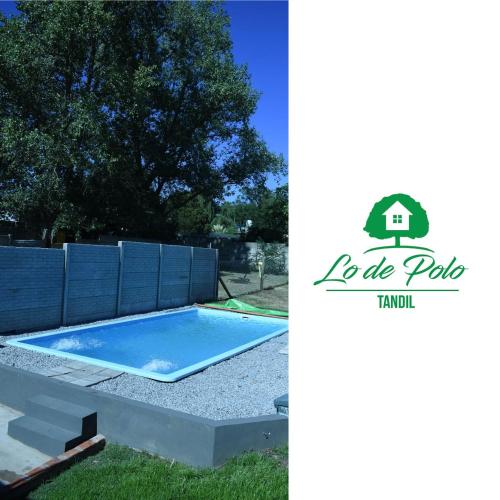 een zwembad voor een achtertuin met een hek en een boom bij Lo de Polo Casa de Descanso in Tandil